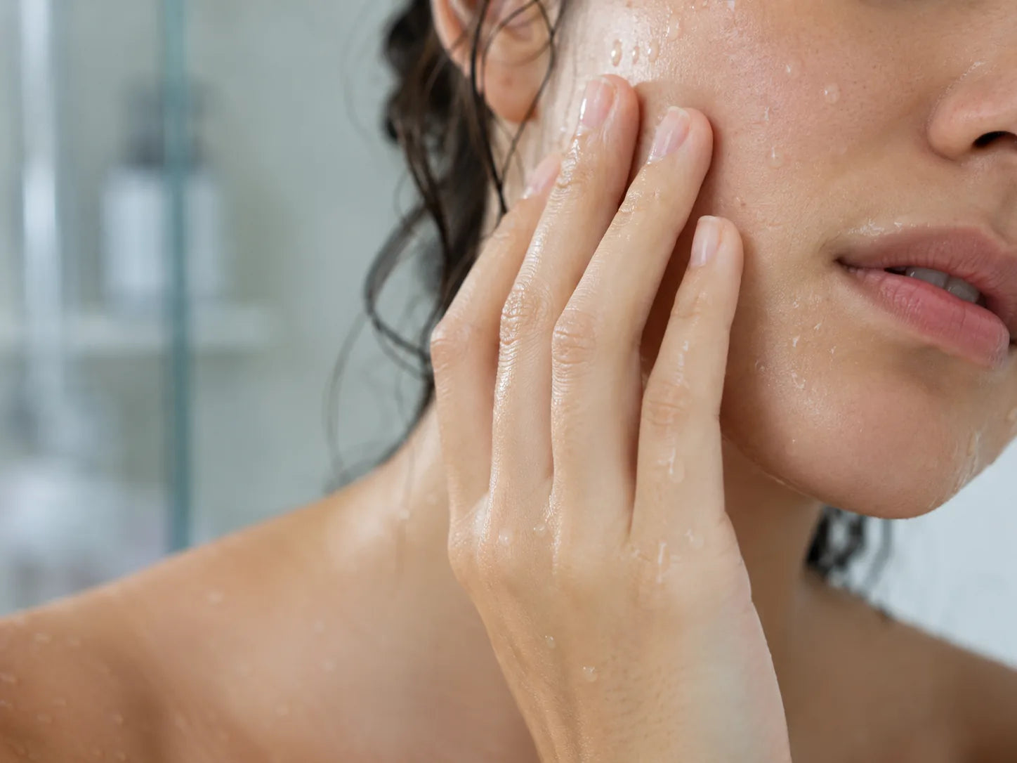 Nasse Gesichtshaut wird nach der Dusche berührt